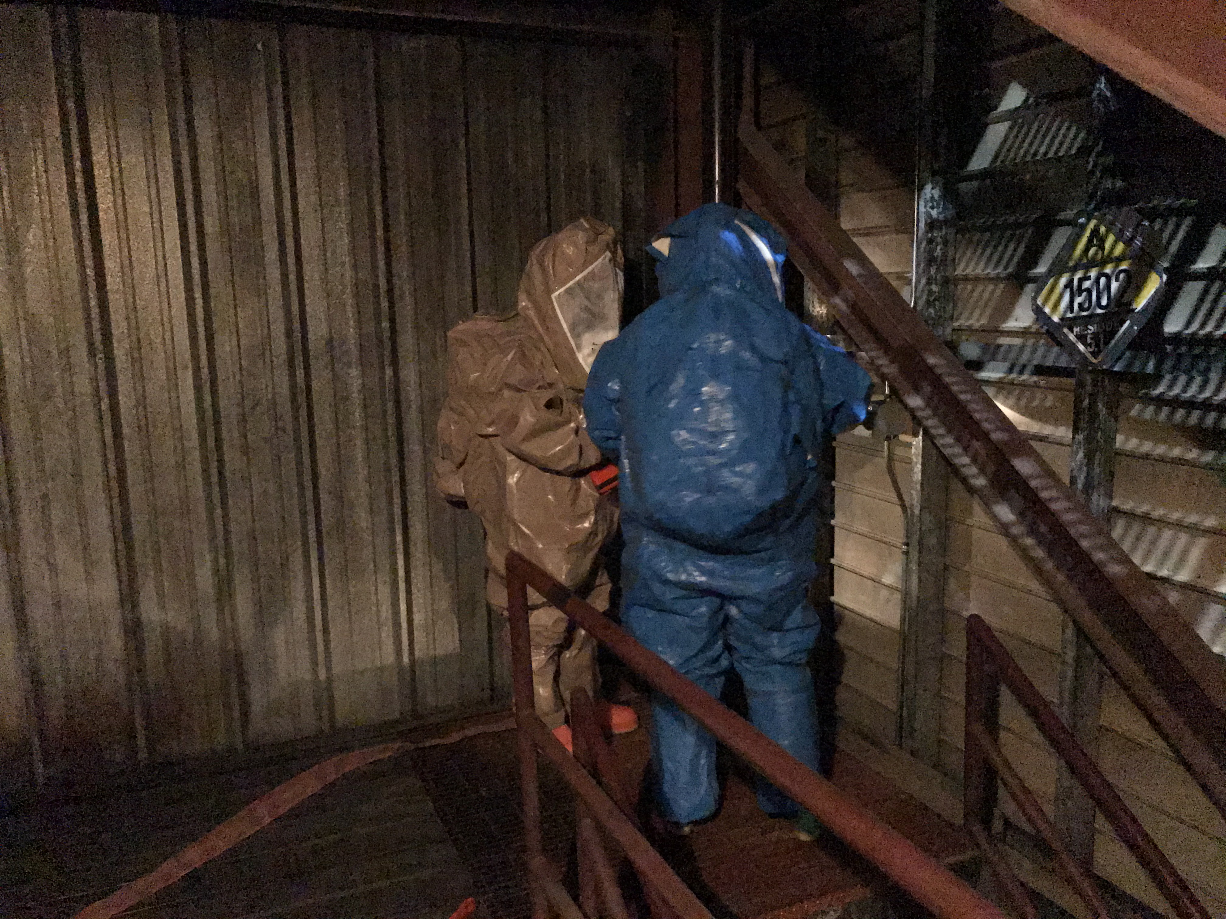 2 men in hazmat suits standing